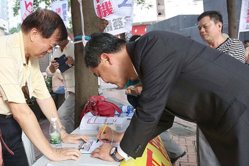 2015年5月15日，特首梁振英到”保普選反暴力大聯盟”設置的街站簽名支持政改。(政府新聞網)