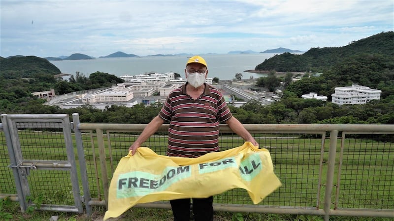 甘浩望神父在石壁監獄附近,手持印有「Freedom For All」的橫額,呼籲港府早日釋放政治犯。(李若如 攝)