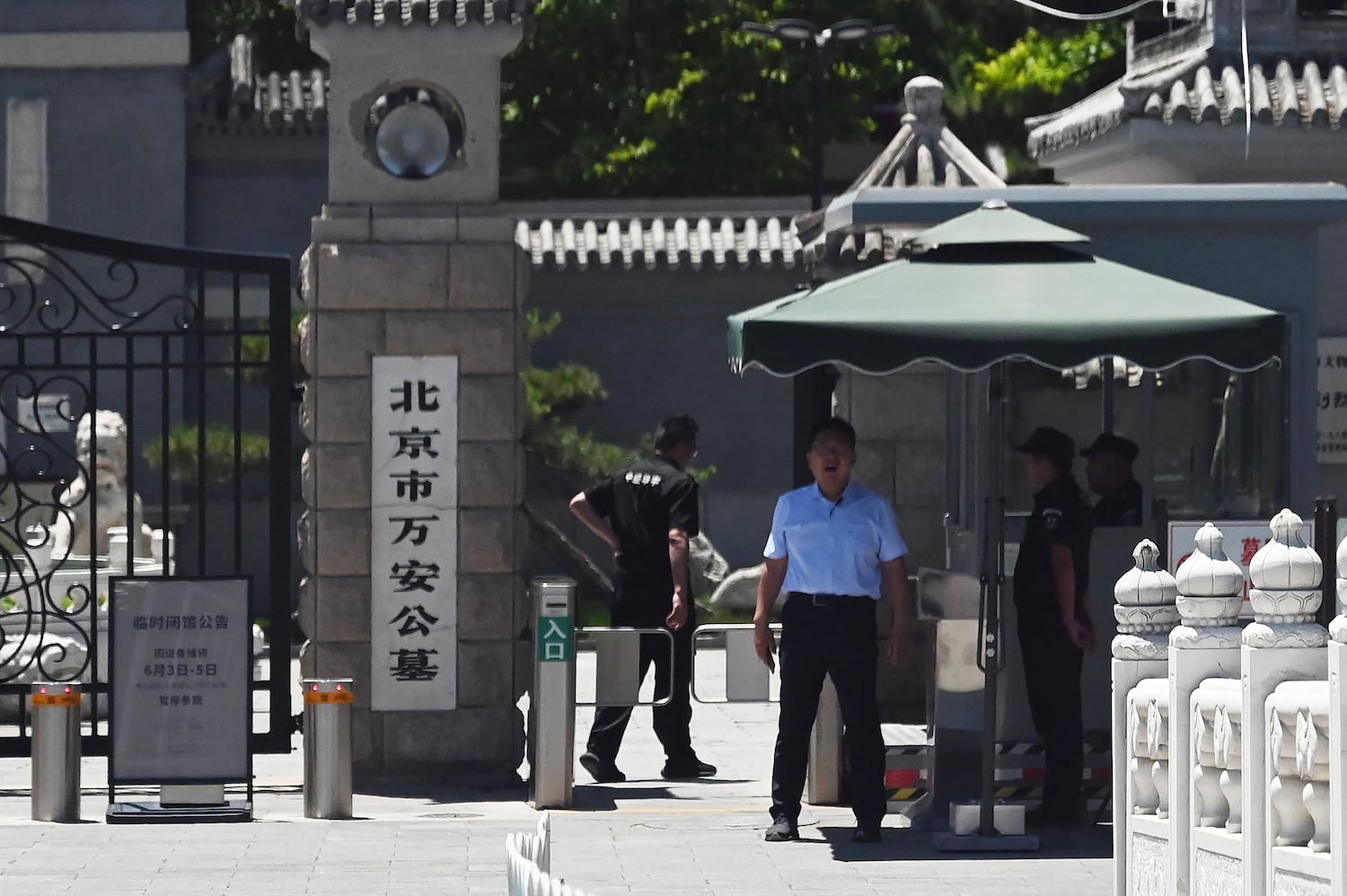Security guards stand at the entrance to Wan'an cemetery where victims of the June 4, 1989 crackdown on Tiananmen Square democracy protests are known to be buried, in Beijing on June 4, 2025.