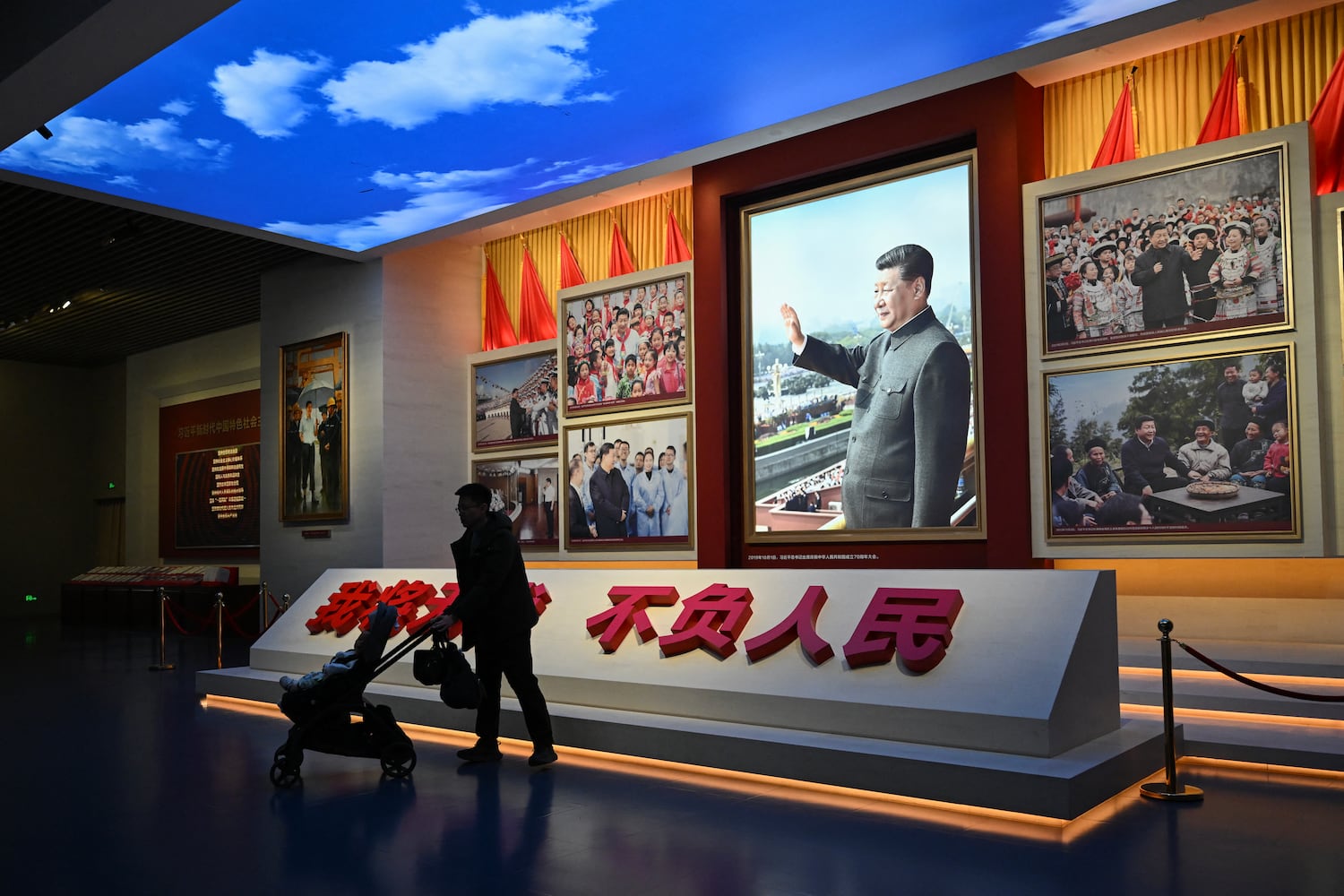 A man walks past portraits of China's President Xi Jinping at the Museum of the Communist Party of China in Beijing on March 1, 2026.