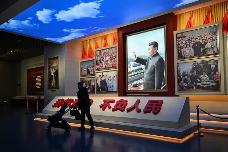 A man walks past portraits of China's President Xi Jinping at the Museum of the Communist Party of China in Beijing on March 1, 2026.