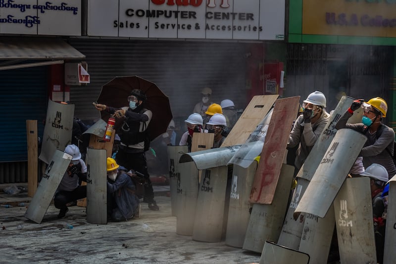 Protesters defend themselves with makeshift shields during clashes with riot police on February 28, 2021 in Yangon, Myanmar. Myanmar's military government has intensified a crackdown on protesters in recent days, using tear gas, charging at and arresting protesters and journalists.