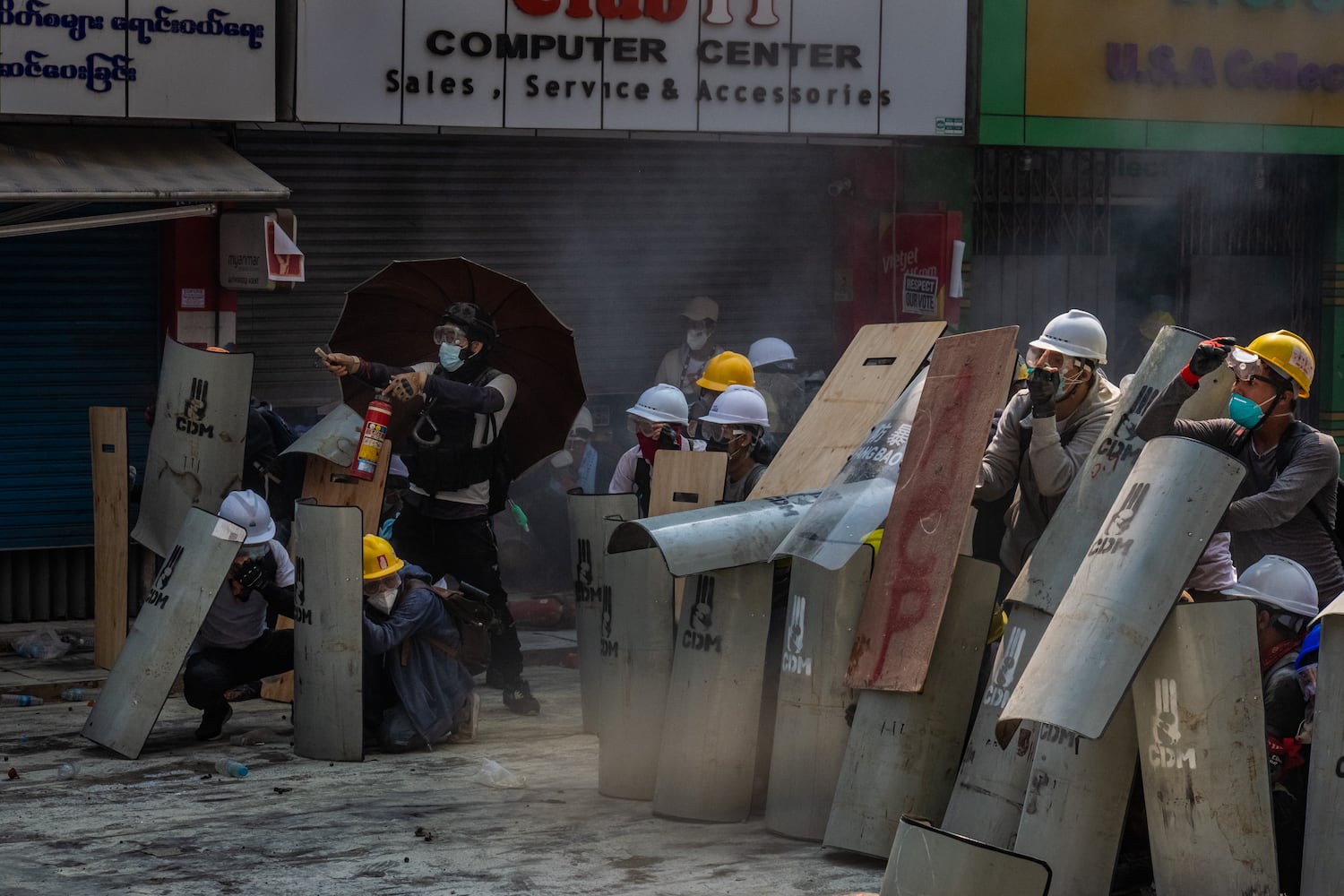 Protesters defend themselves with makeshift shields during clashes with riot police on February 28, 2021 in Yangon, Myanmar. Myanmar's military government has intensified a crackdown on protesters in recent days, using tear gas, charging at and arresting protesters and journalists.