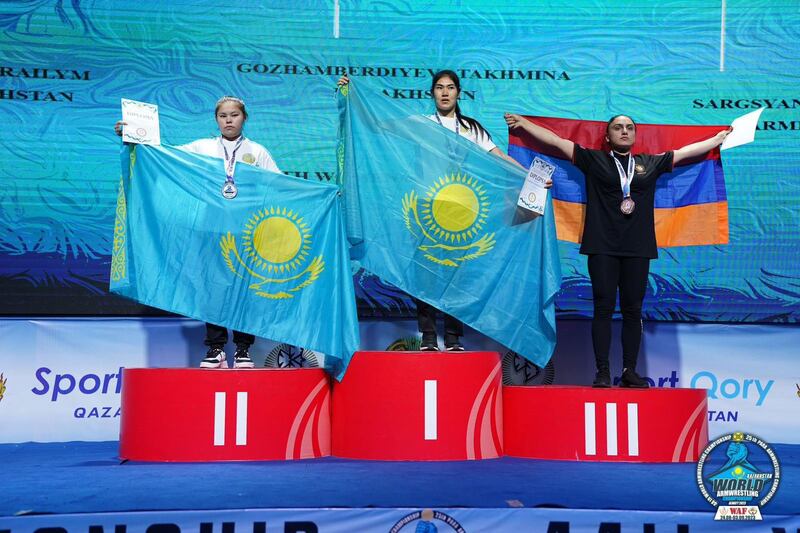 بىلەك بىلەن كۈچ سىنىشىش بويىچە دۇنيا چېمپىيونى تەخمىنە غوجامبەردىيېۋا (ئوتتۇرىدا). 2023-يىل. ئالمۇتا.