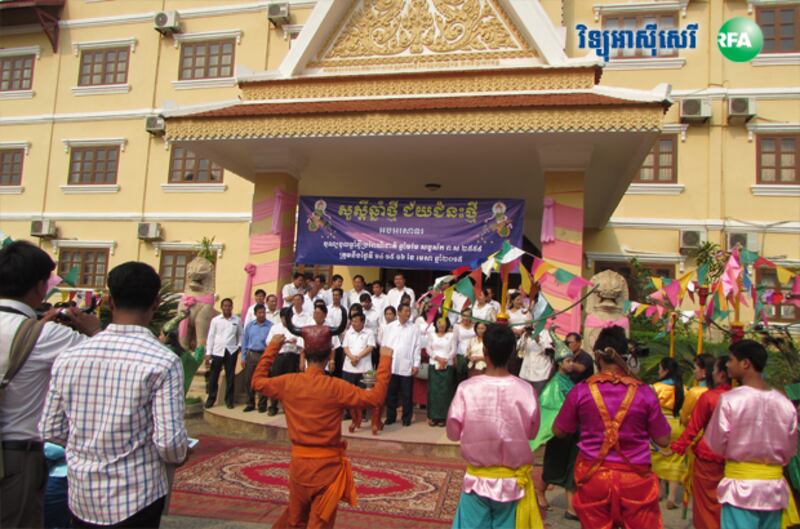 មន្ត្រី​សាលា​ខេត្ត​បាត់ដំបង ឈរ​មើល​ក្រុម​សិល្បៈ​នៃ​មន្ទីរ​វប្បធម៌​ខេត្ត​សម្ដែង​ក្នុង​ឱកាស​ក្រុង​ពាលី សូត្រ​មន្ត​បុណ្យ​ចូល​ឆ្នាំ​ថ្មី​ប្រពៃណី​ជាតិ នៅ​ខាង​មុខ​អគារ​សាលា​ខេត្ត កាល​ពី​ថ្ងៃ​ទី​៨ ខែ​មេសា ឆ្នាំ​២០១៥។ 