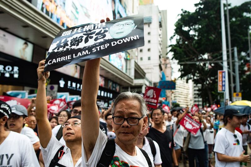 2019年6月9日,香港民间人权阵线举行反对修订《逃犯条例》的大游行,示威群众手持着标语“林郑月娥下台”。(法新社)