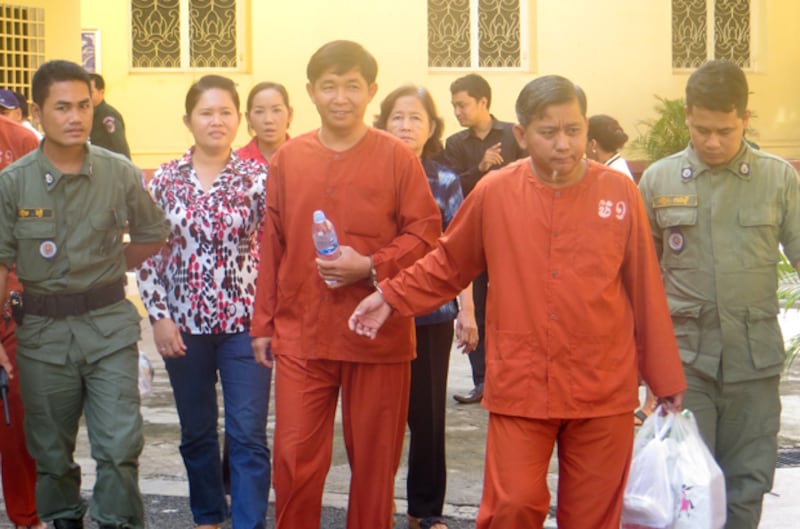 (ដៃ​ជាប់​ខ្នោះ) អតីត​នាយ​រង​នគរបាល​ព្រហ្មទណ្ឌ​កម្រិត​ស្រាល លោក លី រ៉ាស៊ី (ឆ្វេង) និង​លោក ហង្ស វុត្ថា ចេញ​ពី​ស្តាប់​ការ​ប្រកាស​សាល​ដីកា​របស់​តុលាការ​កំពូល ពាក់ព័ន្ធ​សំណុំ​រឿង​ប៉ុនប៉ង​ធ្វើ​ឃាត លោក សៅ សុខា នៅ​ថ្ងៃ​ទី​២៤ ខែ​តុលា ឆ្នាំ​២០១៤។ 