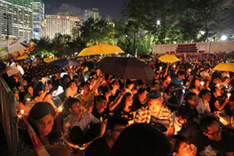 2015年6月4日晚上，一些參加燭光晚會的市民，亦不忘撑黃傘。 (粵語組記者文宇晴攝)
