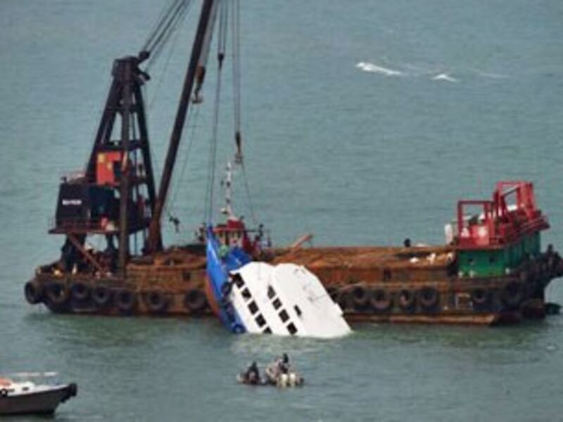 图片：海事救援部门正在打捞被撞沉的船（AFP）