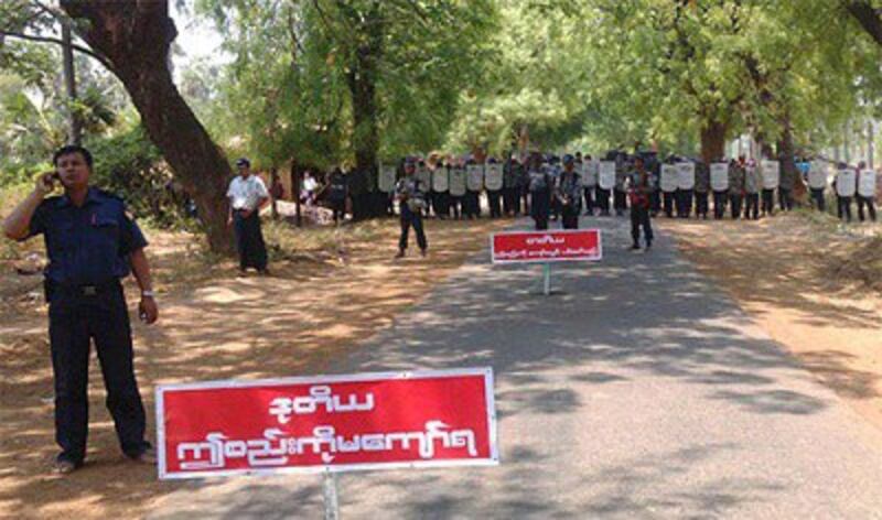 Security forces stand behind a sign warning protesters not to go any further, April 26, 2013. Photo credit: RFA.