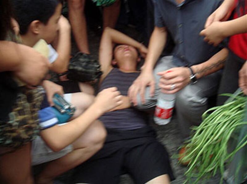 2012年7月16日,重慶永川區城管向老小販暴打執法,引起途人圍觀,一名青年拍下過程被城管毆打倒地。(永青橋影印店負責人提供)