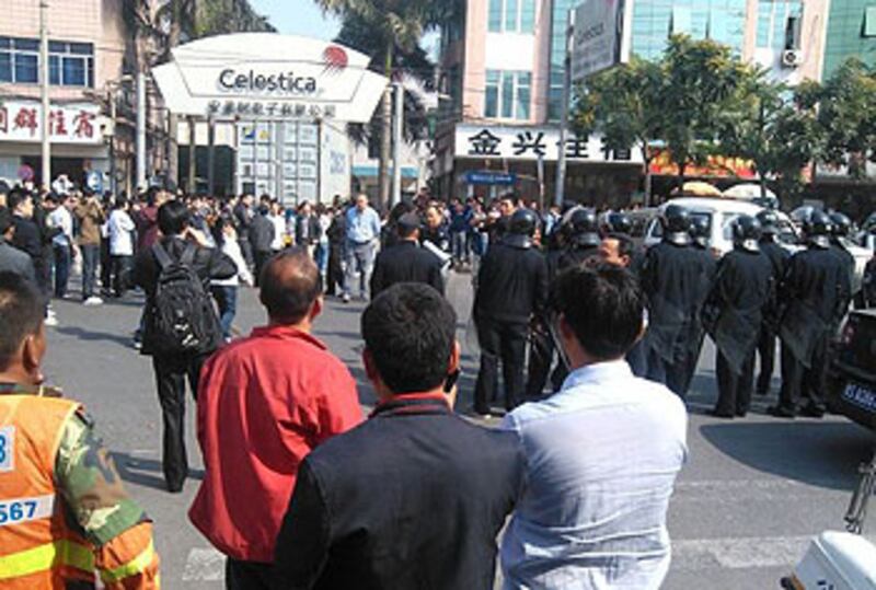 2013年3月6日，東莞市安美時電子廠即將關閉，上千員工不滿資方作出的調遷和賠償安排，因而罷工堵路，防暴警員到場維穩。（網民提供）