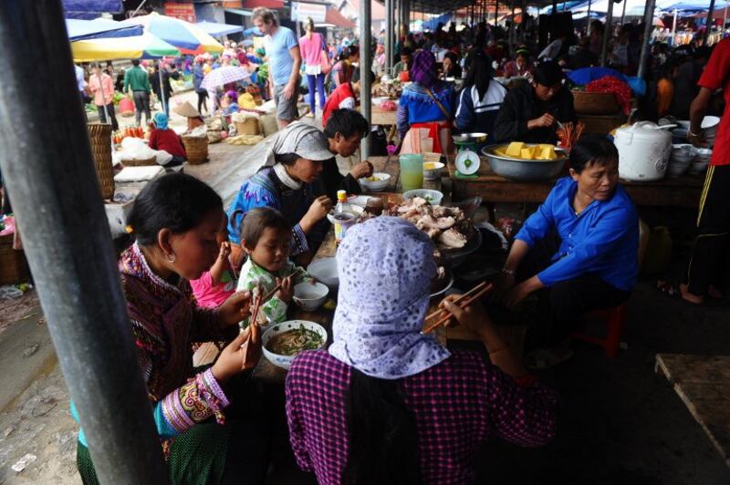 Hình minh họa. Hình chụp hôm 2/11/2014: những người H'mong tại một quầy bán đồ ăn làm từ lòng lợn ở một chợ tại Bắc Hà, thành phố Lào Cai