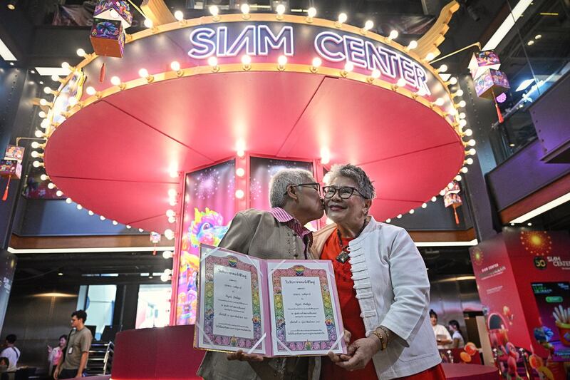 Kan Kerdmeemun (left) and Pakodchakon Wongsupha (right), who have been together for 30 years, pose for photos during a ceremony to unofficially wed LGBTQ+ couples on Valentine’s Day in Bangkok, Feb. 14, 2024. [Lillian Suwanrumpha/AFP]