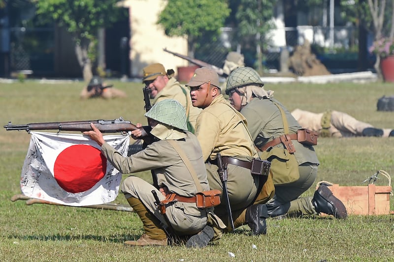 Members of the Living History Society, acting as Japanese soldiers, re-enact a scene of the "Battle of the Pockets" between allied and Japanese forces during World War II, at Camp Aguinaldo in Manila on March 25, 2017.