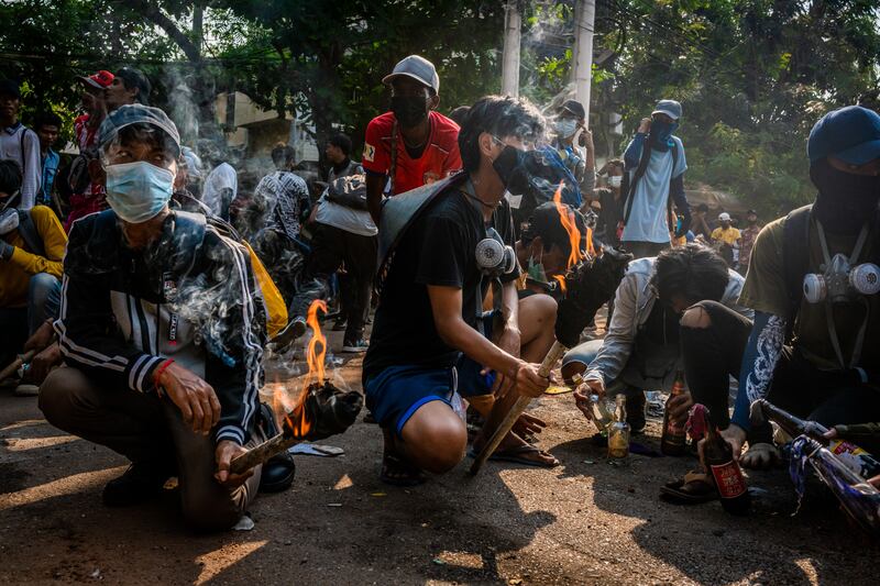 Anti-coup protesters prepare to throw molotov cocktails towards approaching security forces on March 28, 2021 in Yangon, Myanmar.
