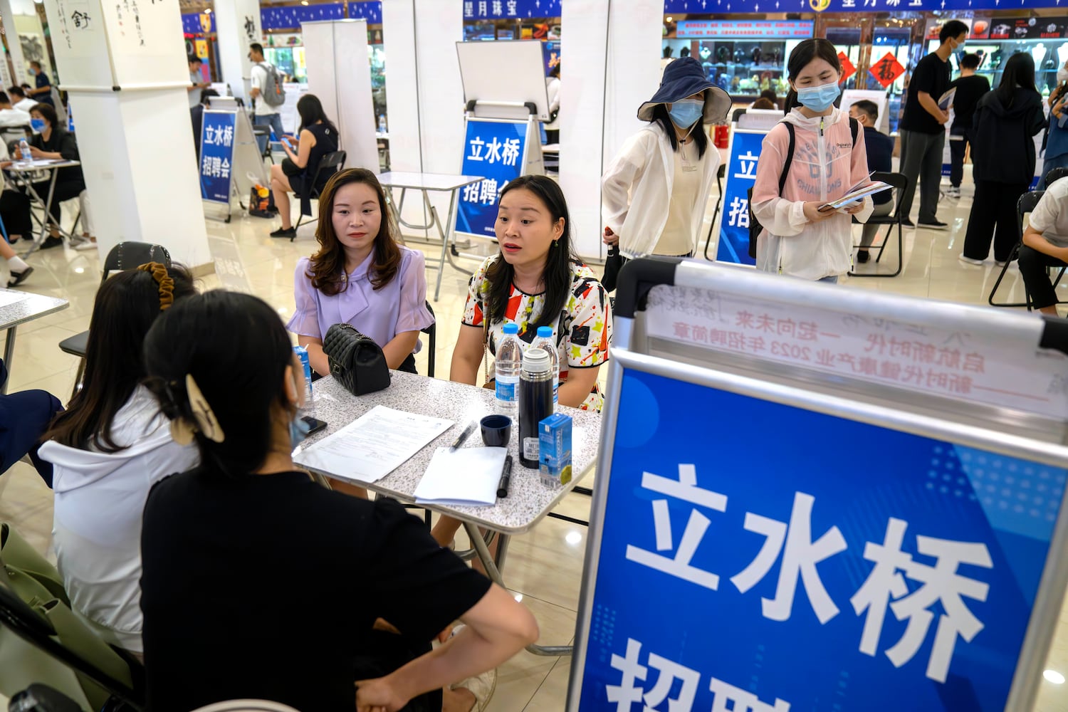 Job seekers talk with recruiters at a job fair at a shopping center in Beijing, June 9, 2023.