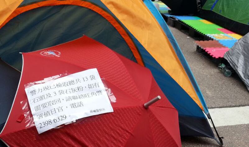 2014年11月13日，旺角佔領區一個帳篷版搜出檢走13袋石頭和3袋石灰粉，警方在涉及的帳幕貼出告示，若有市民想取回物品可到旺角警署。（粵語部記者林靜攝）