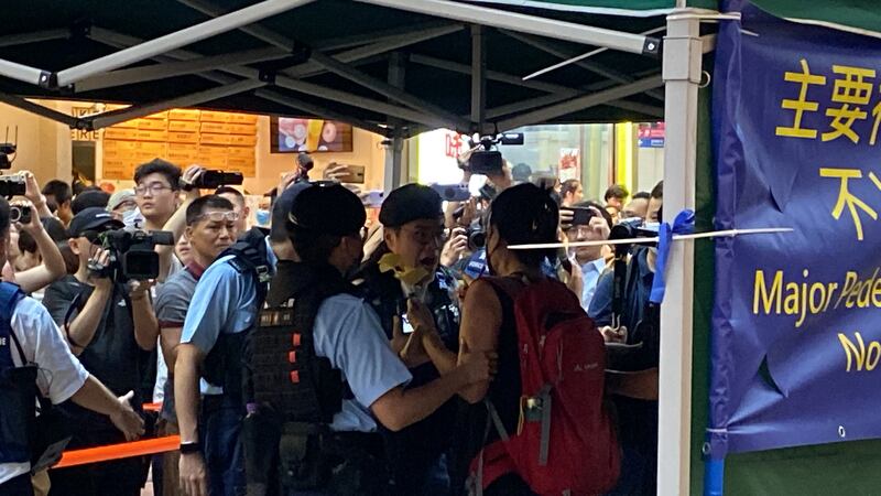 社民連主席陳寶瑩手持黃色花及電子蠟燭,其後被警方帶走。(董舒悅 攝)