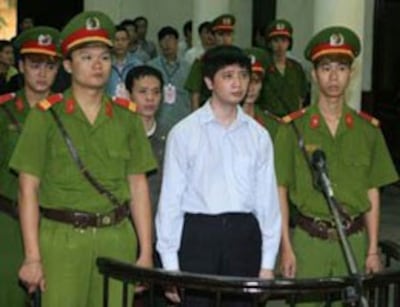 Anh Vũ Đức Trung (giữa, hàng đầu) và anh Lê Văn Thành (giữa, sau anh Trung), hai học viên Pháp Luân Công tại Tòa án nhân dân Hà Nội sáng 10/11/2011.AFP