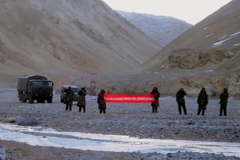 Chinese troops hold a banner reading: "You've crossed the border, please go back" in Ladakh, India, May 5, 2013. (AP)
