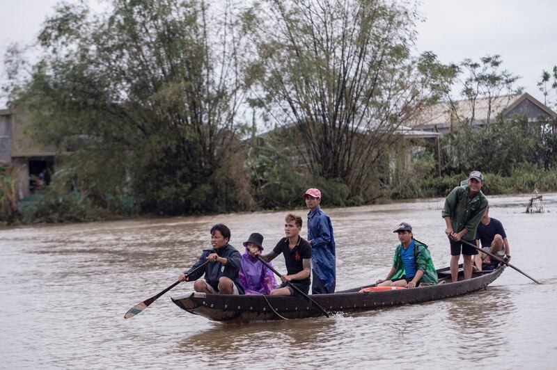 Cư dân địa phương chèo thuyền đến điểm đón để chuyển hàng cứu trợ cho người dân bị ảnh hưởng bởi lũ lụt lớn ở xã Quảng An, Thừa Thiên Huế, Việt Nam, ngày 20 tháng 10 năm 2020.