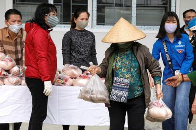 Một phụ nữ nhận thức ăn quyên góp cho người nghèo trong đợt dịch COVID-19 tại Hà Nội, ngày 7 tháng 4 năm 2020.