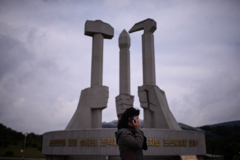 평양의 '조선로동당 창건 기념탑' 앞에서 휴대전화로 통화하고 있는 북한 여성.