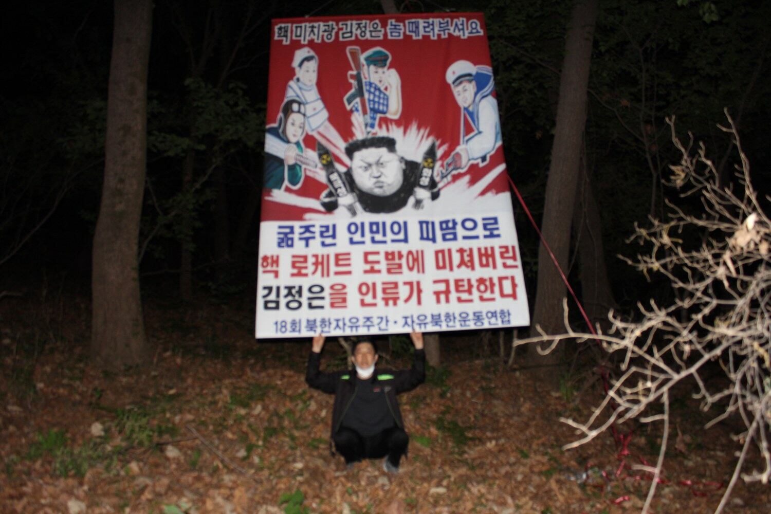 탈북민단체인 자유북한운동연합은 지난달 25일부터 29일 사이 비무장지대(DMZ)와 인접한 경기도와 강원도 일대에서 대북전단을 살포했다고 주장했다. 사진은 박상학 자유북한운동연합 대표가 북한 정권을 규탄하는 플래카드를 들고 있는 모습이며 촬영 장소는 공개하지 않았다.