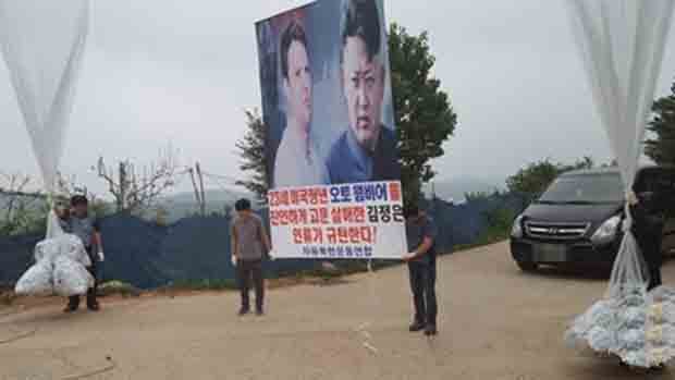 22일 오전 경기도 김포시 월곶면 문수산에서 탈북민단체 자유북한운동연합 회원들이 대북전단을 타이머와 함께 대형 풍선에 매달아 북한으로 띄워 보내고 있다.