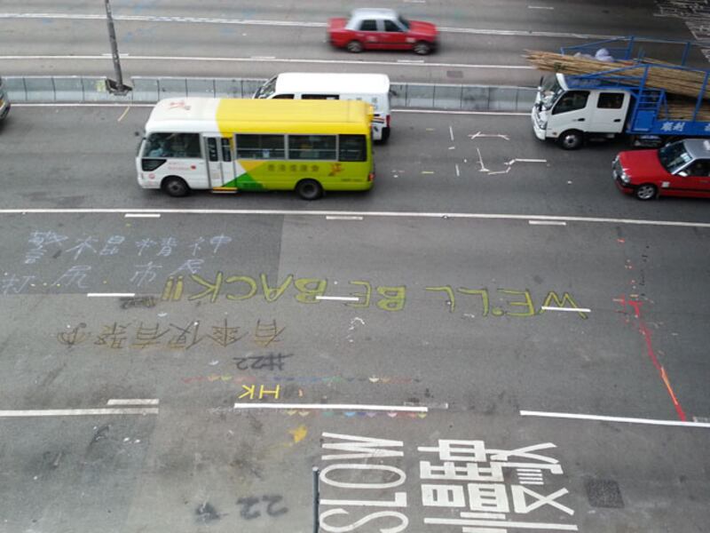 2014年12月12日，金鐘夏愨道已全面清場，但東行線上的”WE WILL BE BACK”仍現清晰可見。（粵語部林靜攝） 