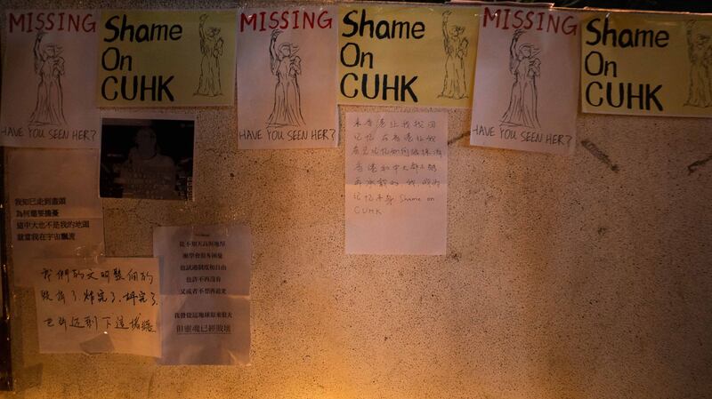 香港中文大学民主女神像被拆后，中大师生在女神像原址空地上放下鲜花、点上烛光悼念。(AFP)