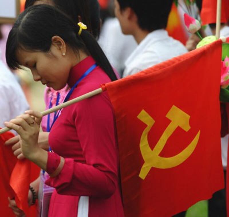 Một sinh viên Việt Nam cầm cờ Đảng cộng sản tại Hà Nội. AFP photo