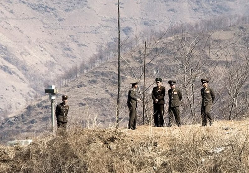 북한 군인들이 압록강변의 감시카메라 주변에서 대화를 나누고 있다.