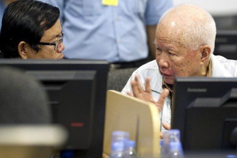 Khieu Samphan (left) speaks to his lawyer in the ECCC courtroom in Phnom Penh on Oct. 16, 2013. Photo credit: AFP Photo / ECCC / Mark Peters.