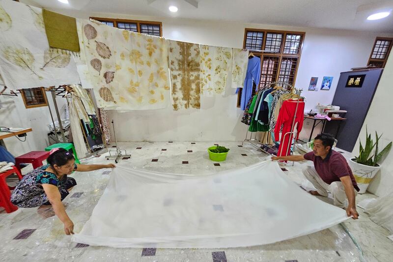 ပိတ်စအဖြူပေါ် သဘာဝသစ်ရွက်များနှင့် အရောင်ဆိုးပြီး လက်မှုအထည် ဒီဇိုင်းပြုလုပ်နေပုံကို ၂၀၂၄ ခုနှစ် ဇန်နဝါရီလ ၂၄ ရက်နေ့က တွေ့ရစဉ်။ (Photo: RFA)