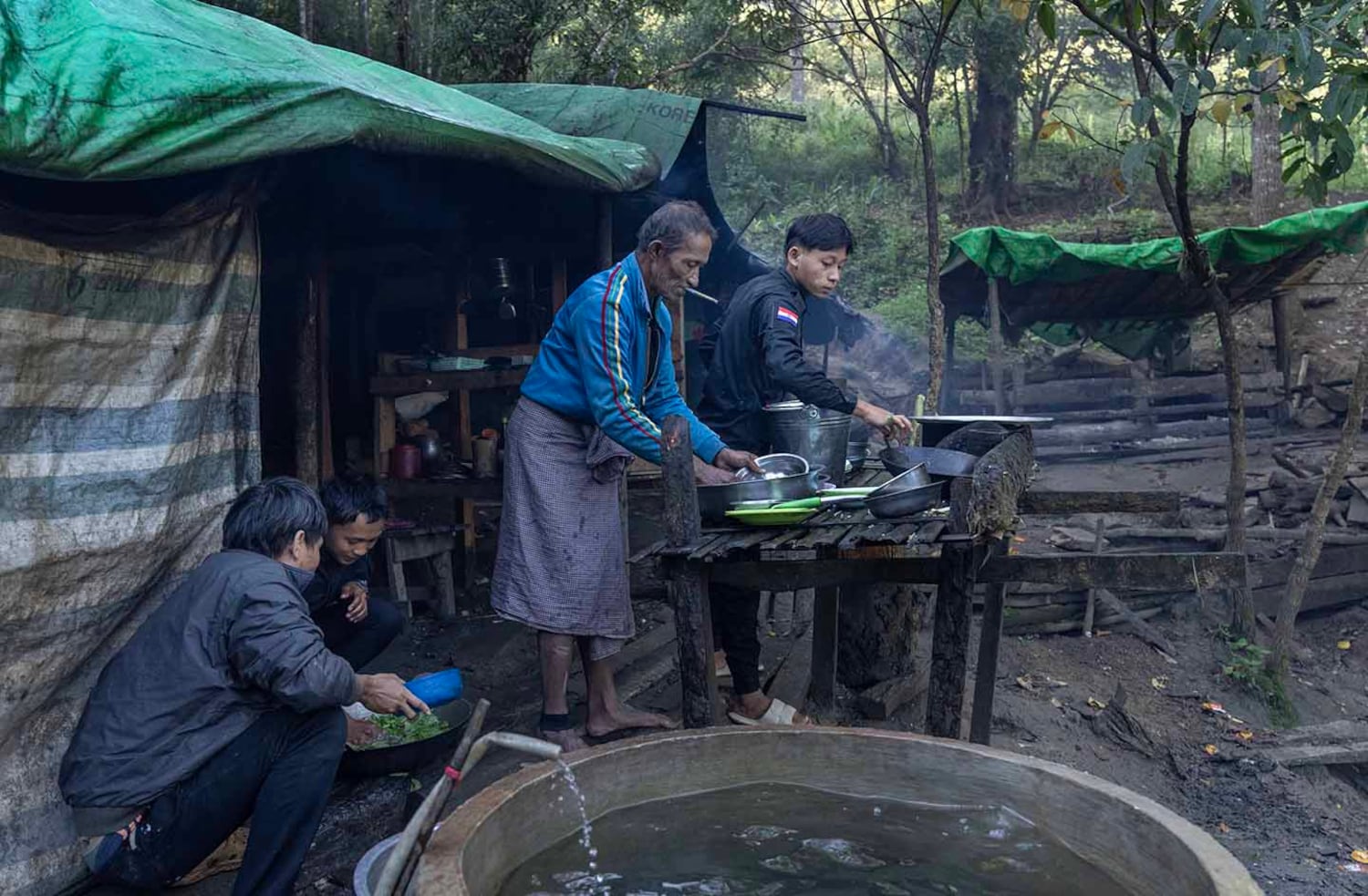 A detainee washes dishes at KSP Station 8 in southern Shan state, Myanmar, Nov. 4, 2024. The station lacks funds to hire services, so detainees help with cooking and general cleaning.