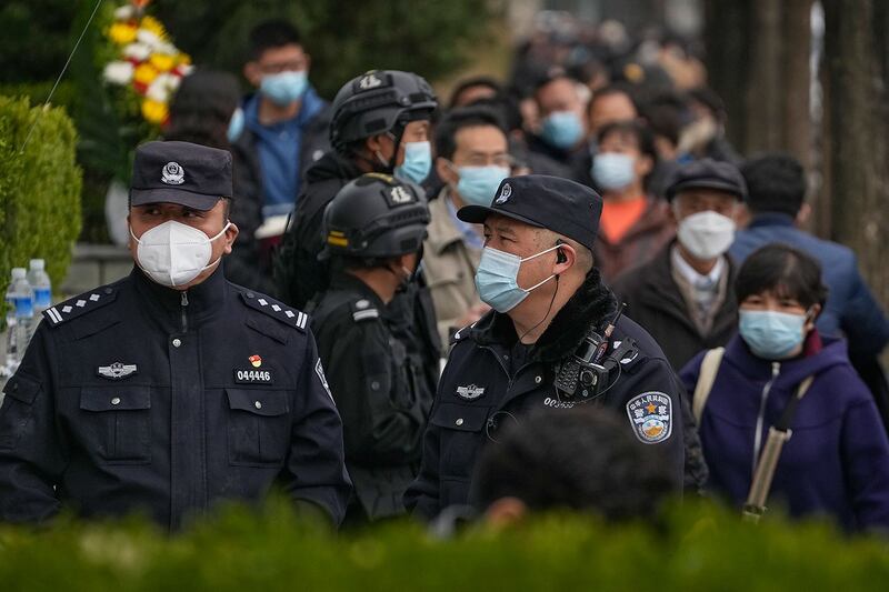 2023年4月5日清明节,警察和保安在北京一处墓地门口站岗。(美联社)