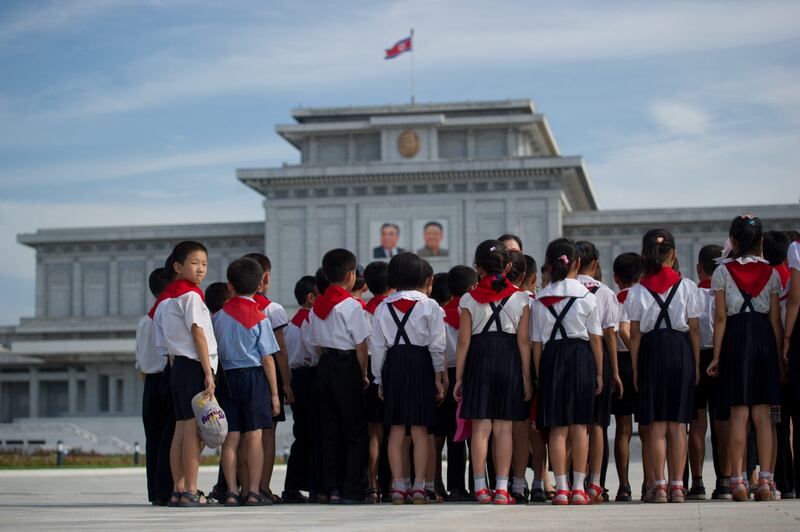 2013년 7월, 교복을 입은 북한 학생들이 금수산태양궁전에서 고(故) 김일성(왼쪽)과 김정일(오른쪽) 북한 지도자들의 초상화 앞에 서 있다.