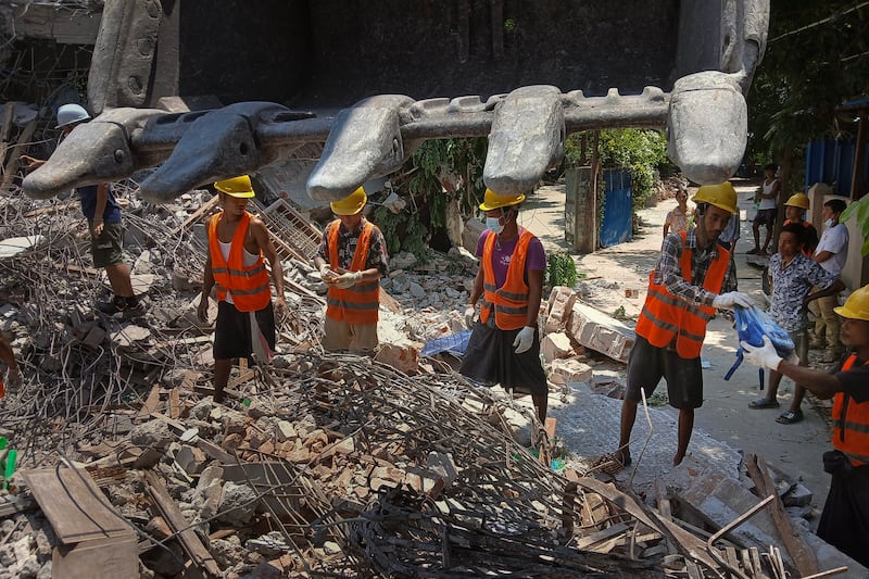 Workers retrieve children's belongings at a destroyed pre-school in Sagaing city, Myanmar, on April 24, 2025, four weeks after Myanmar's devastating earthquake.