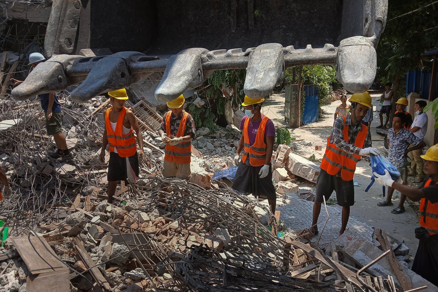 Workers retrieve children's belongings at a destroyed pre-school in Sagaing city, Myanmar, on April 24, 2025, four weeks after Myanmar's devastating earthquake.