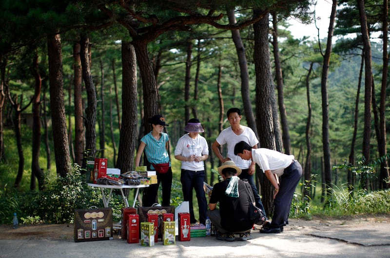 2011년 9월, 금강산 리조트에서 한 지역 상인이 중국 관광객에게 지역에서 생산한 와인, 꿀, 잼을 판매하고 있는 모습.