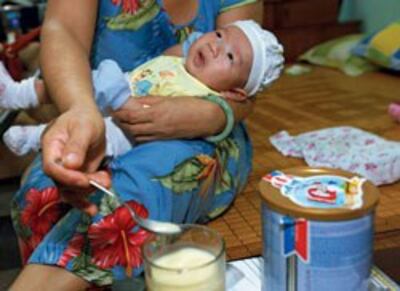Một em bé đang được cho uống sữa bột. Courtesy sgtt.vn
