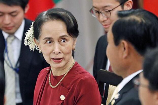 Myanmar State Counselor Aung San Suu Kyi (L) talks with Thai Prime Minister Prayuth Chan-ocha (R) during a dinner in Tokyo, Oct. 8, 2018.