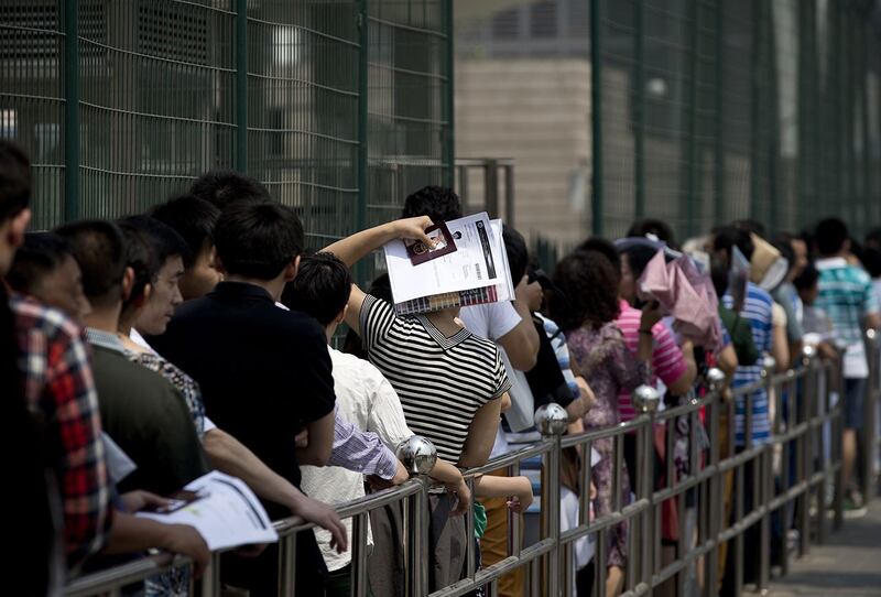 资料照：中国公民在北京美国大使馆外排队申请签证。（美联社）