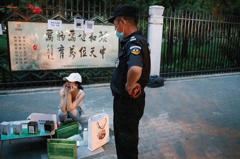 图为,2020年6月8日,北京一名城市执法人员命令街头小贩收摊。(路透社)