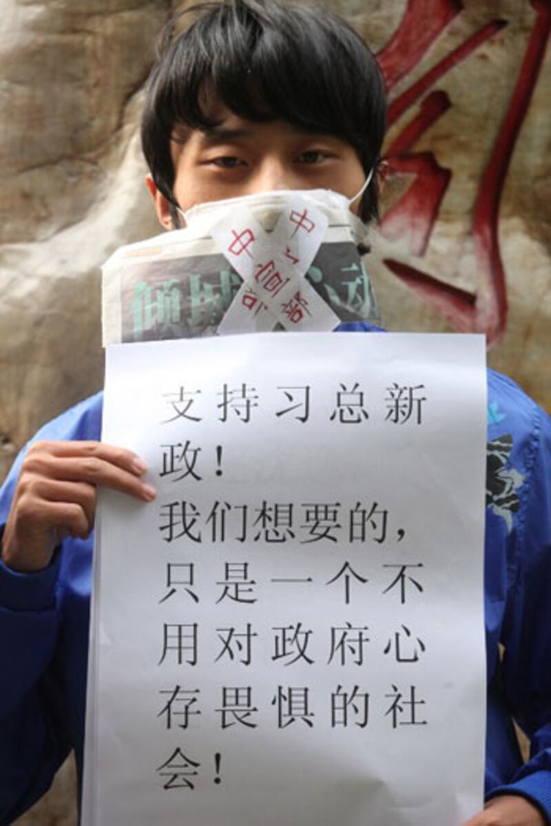 1月10日（星期四），一位來自廣州大學的學生中印有“中宣部”的字條封住自己的嘴巴，站在南方傳媒大廈前聲援南方週末。（法新社Jonathan Wu/EyePress）