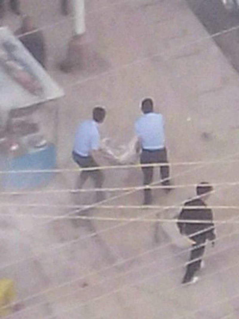 图片:四川阿坝警方8月13号抬走自焚藏人扎西。(达兰萨拉格尔登寺提供)