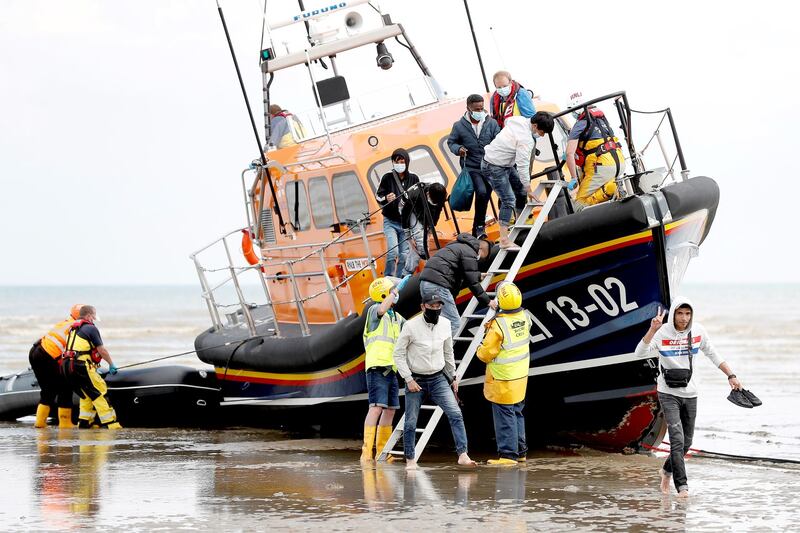 Migrants from nations that include Vietnam leave an RNLI vessel after being rescued in the English Channel, following their departure from northern France, in Dungeness, Britain, August 4, 2021. Credit: Reuters