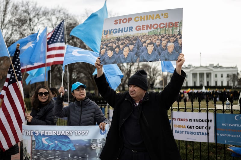 People hold up flags and signs during a protest in Washington, Feb. 5, 2023. The U.S. formally declared China's actions towards the Uyghurs as genocide in 2021.